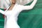 Sexy business woman holds Turkmenistan flag in hands behind her back on the office building background - flag concept 3d
