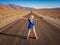 Sexy curvy woman stands on lane of Badwater Road, Death Valley, California