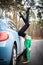 Sexy, flexible woman on the heels with car on the road. Concept of sexuality and seduction