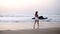 Sexy girl in a bathing black suit and white shirt tight on belly walks over a sandy beach at the ocean - gorgeous long