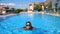 Sexy girl in black swimsuit relaxing in pool of luxury hotel. Lady resting on resort. Young woman in sunglasses swimming