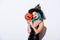 Sexy girl in black witch Halloween costume with blue hair holding spooky carved pumpkin