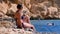 Sexy Girl Sitting on the Cliff on the Rocky Beach of Egypt by the Red Sea