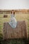 Sexy girl in underwear posing on a haystack in summer at sunset