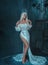 Sexy, gothic, snow queen in a white vintage dress posing with a bare leg. A blonde girl in a crown with icicles on a