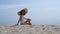 Sexy lady sitting sand in front blue sky wearing brimmed hat. Woman enjoy beach.