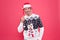 Sexy man santa earflap hat. unshaven man funny sweater red background. male cold weather fashion. santa man ready for