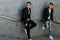 Sexy mans posing near railing. Handsome young mans in stylish black clothes and white shoes posing near a railing