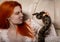 Sexy redhead woman holding snake. close-up photo girl with pygmy python on a white background