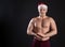 Sexy Santa Claus. A young handsome demonstrates cubes of the press, falls in love with everyone on a black background. In a red