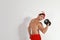 Sexy shirtless Santa Claus  dumbbell on light background, space for text