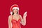 Sexy smiling girl in swimsuit christmas hat demonstrate invisible product finger. Recommend advertising concept. Magazine collage