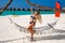 Sexy tanned woman bikini model at Maldives tropical sand beach. Glamour girl in swimsuit on hammock in paradise. Perfect body