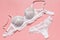 Sexy white lace bra and panties on pink background. Stylish lingerie flat lay. Underwear fashion concept