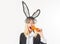 Sexy woman, Easter bunny eating carrot. Sensual woman wearing black lace rabbit ears isolated on white.