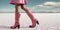 Sexy woman wearing pink cowboy boots made of alligator leather in the desert. Ai Generative image