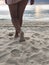 Sexy women`s tanned legs in the white fine sand of the unique Karon beach of Phuket on the background of the sea and the Golden