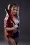 Sexy young woman in the image of Harley Quinn with a bat in her hands