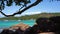 Seychelles. Praslin Island. Beautiful private yacht in the blue sea water on the background. Shooting from behind trees