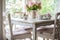 shabby chic dining table and chairs with a vase of fresh flowers
