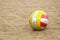 Shabby dirty volleyball on sand. Attribute of beach volleyball, sports games on the coast