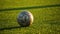 Shabby soccer ball lies on the football field, close up