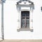 Shabby window in white wall of old russian house