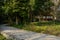 Shaded curving path outside traditional buildings in woods of sunny winter afternooon