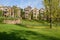 Shaded grassy lawn before hillside houses in sunny autumn afternoon