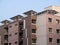 Shades of brown painted apartment buildings blocks with solar panels mounted at the roof top