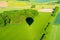 Shadow of a aerostat on green landscape from above