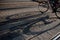 Shadow of a bicycle stretched over the railway on a paved street