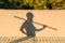 shadow of builder in protective helmet carrying metal structure at construction