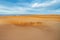 Shadow of camel caravan visible on sand dunes of Sahara desert, Atlas Mountains in the background, Morocco