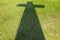 Shadow of Christian cross on green grass floor