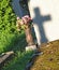 Shadow of cross on the tombstone, grave with artificial flowers