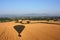 The Shadow of a hot air balloon flying over rural farmland