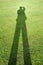 Shadow of a man on background of green grass illustrates the concept of a photographer