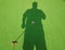 Shadow of man with golf putter on miniature golf hole