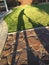 Shadow of Man Pushing Lawn Mower Over Grass