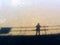 Shadow of person or silhouette alone standing on the bridge and reflection on the river