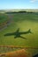 the shadow of the plane on the ground when landing over the jungle