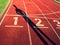 Shadow of runner. White track number on red rubber racetrack, texture of running racetracks