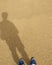 The shadow of a young man standing on the sand in holiday.