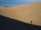 Shadows of child and adult hiking in dunes