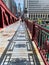 Shadows create patterns on the LaSalle St bridge which is covered with rain puddles, & where commuters rush home