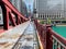 Shadows create patterns on the LaSalle St bridge which is covered with rain puddles, & where commuters rush home during evening