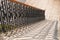 Shadows of decorative cast metal balusters on stone steps