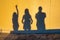 Shadows of a family of three people on the wall at sunset time. Group of human shadows on the stone wall background