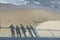 Shadows of group of people on the seashore. Concept of recollection, pandemic, departure to another reality